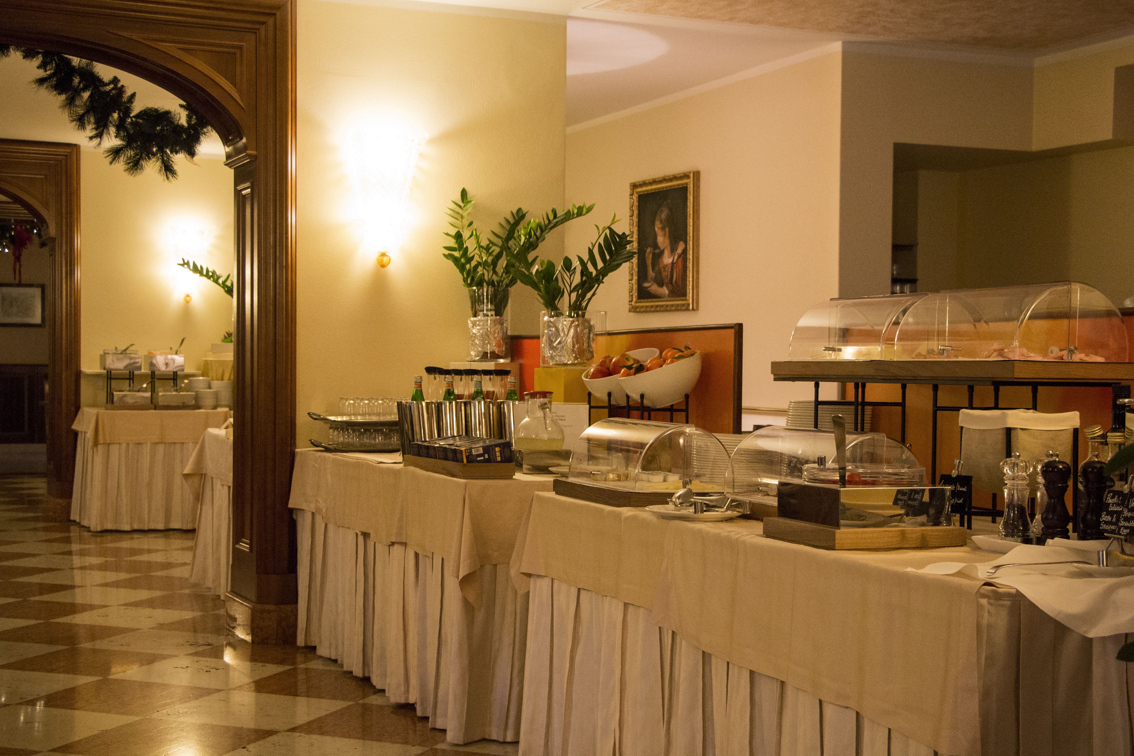 Un buffet proposant une variété de plats et de boissons, notamment un saladier de fruits et un distributeur de boissons.