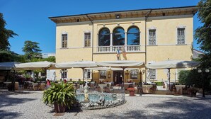 A yellow building with outdoor seating and a fountain.