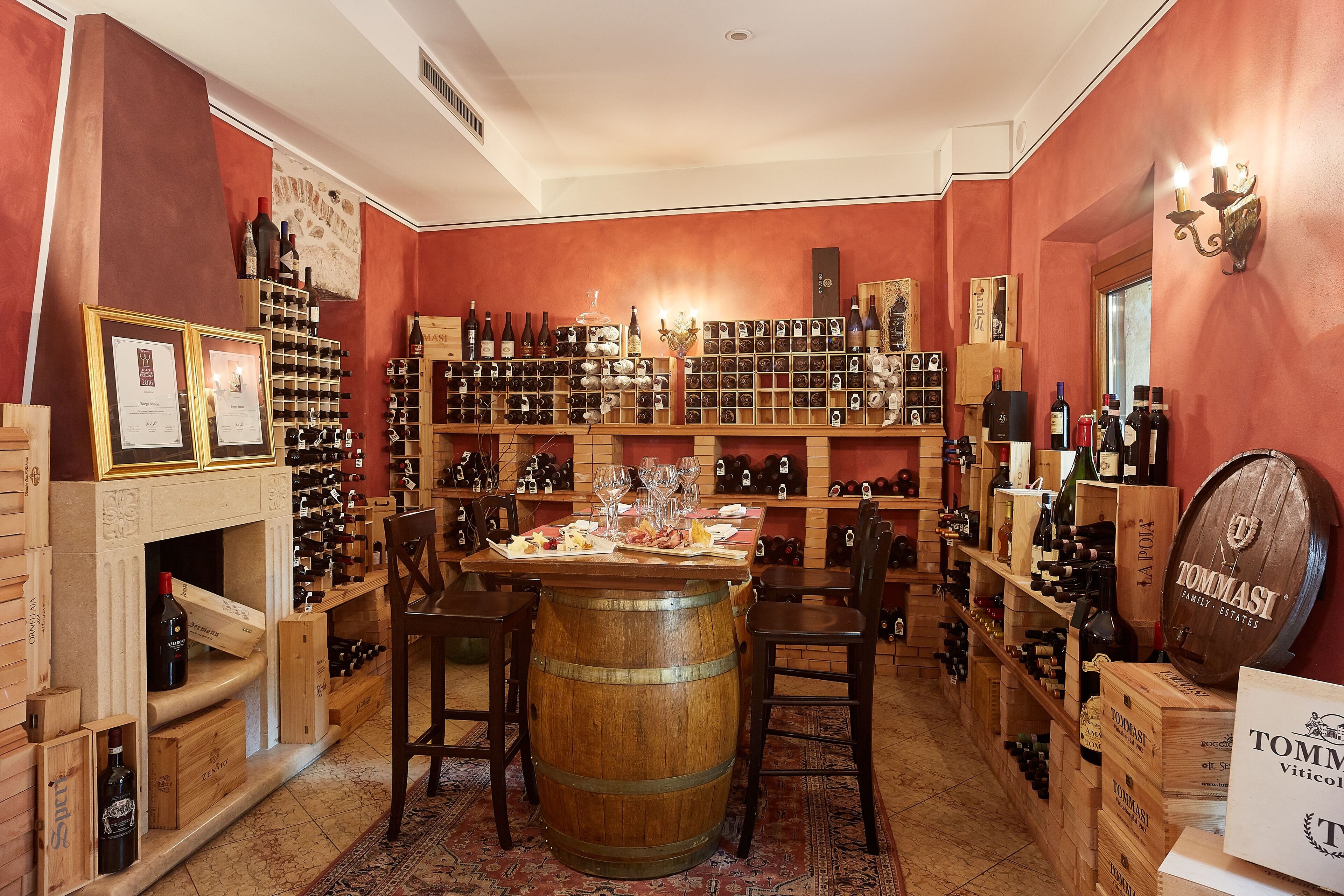 A wine cellar with wooden shelves and barrels, a central bar area, and a red wall.