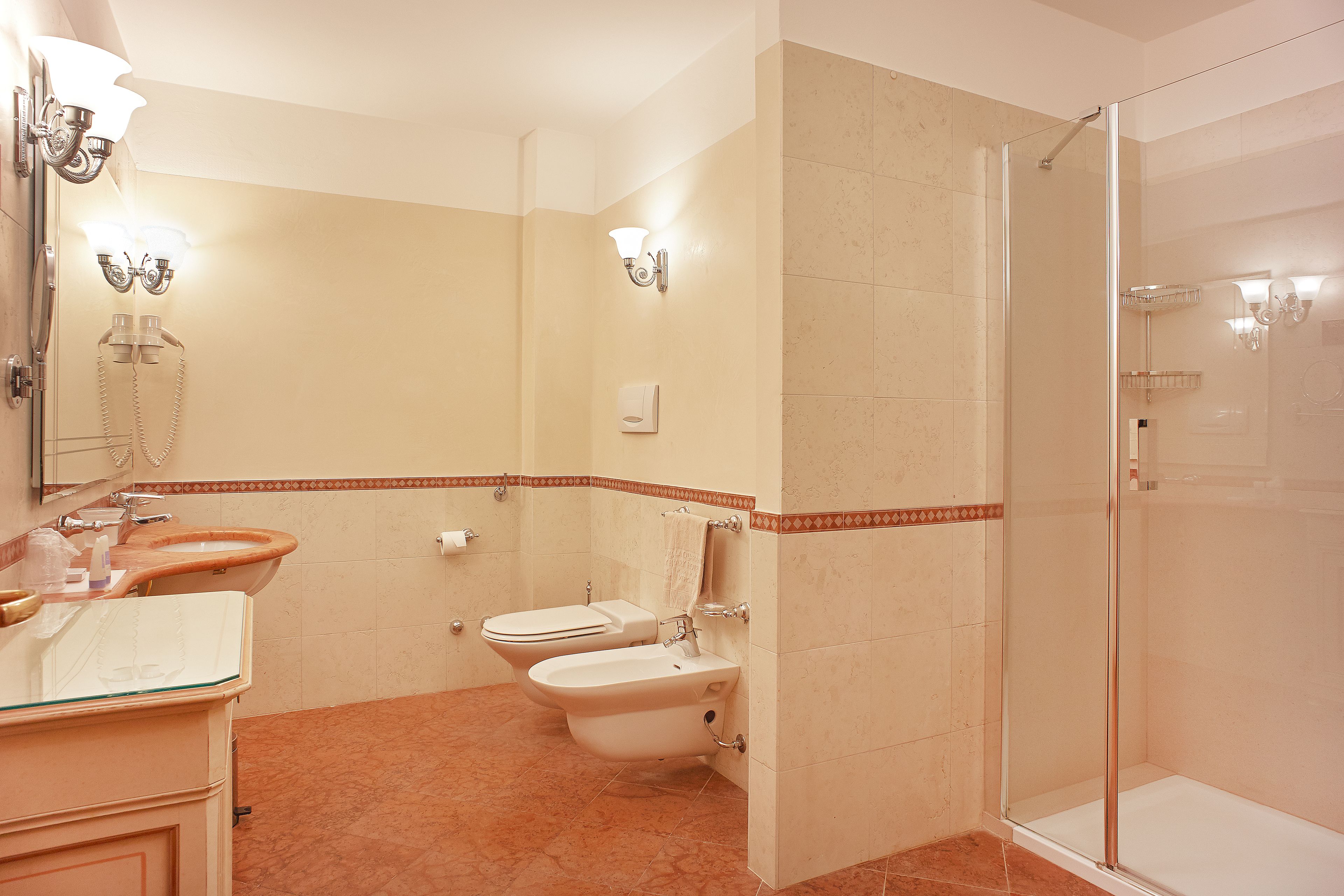 Une salle de bain avec une douche à parois de verre, des toilettes et un lavabo avec un miroir.