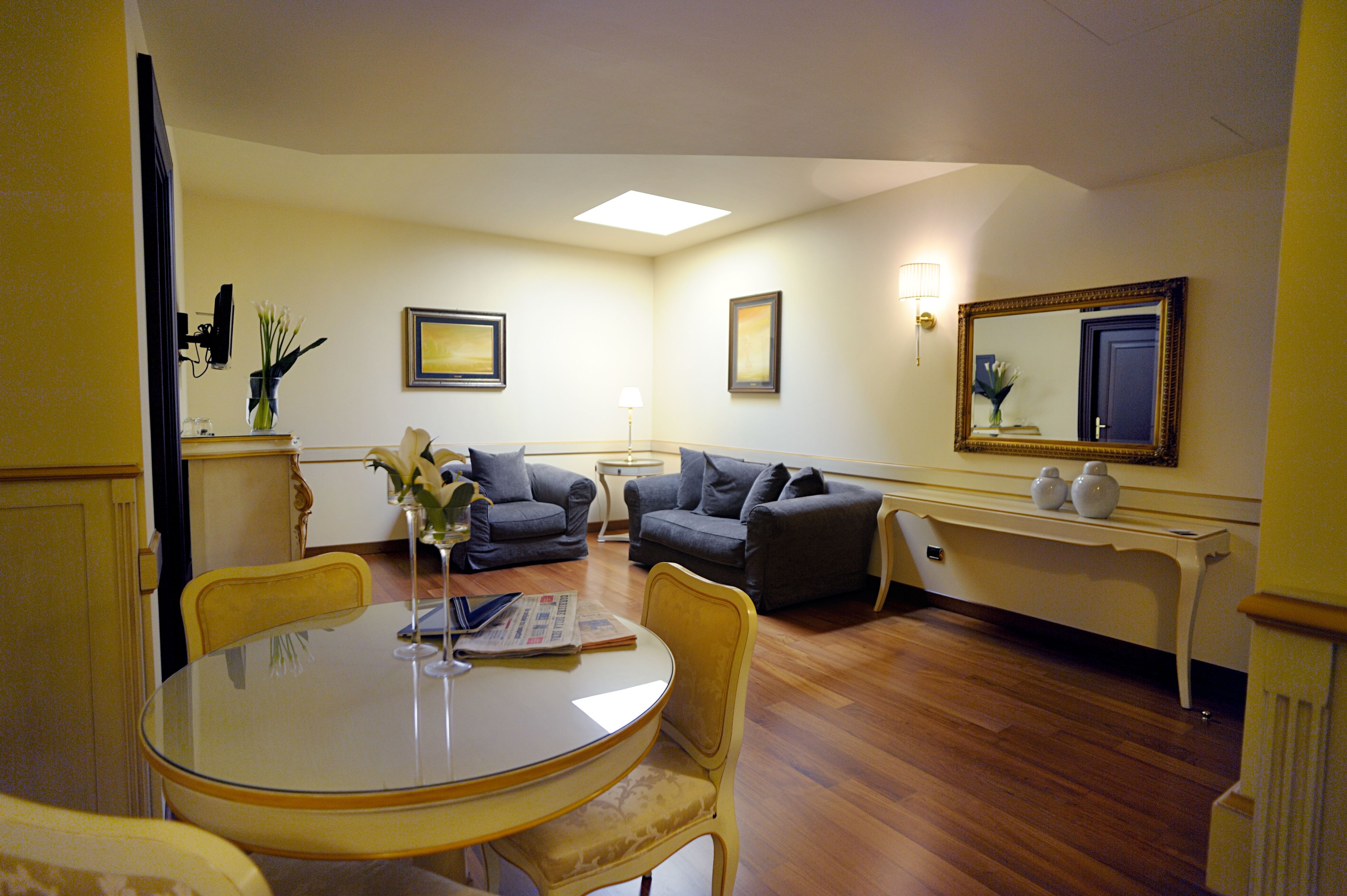 A living room with a round table, two sofas, a coffee table, and a TV.
