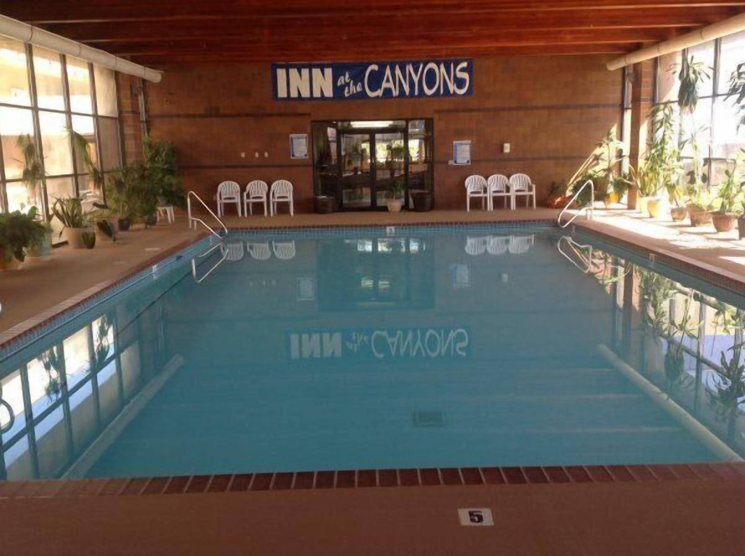 Une piscine intérieure avec une pancarte indiquant « INN at the CANYONS » et une vue sur l’intérieur de la piscine.