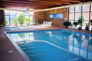 An indoor swimming pool with lounge chairs and potted plants. - Inn at the Canyons (Monticello)
