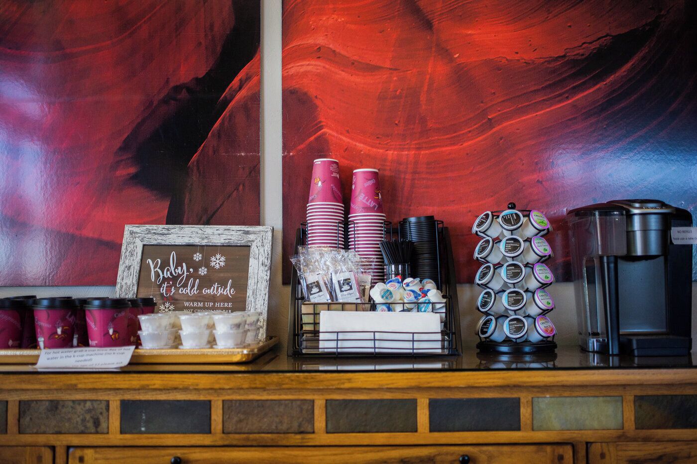 Una estación de café con un cartel que dice 'Baby, it's cold outside' y una máquina de café.