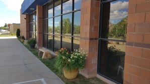 A building with large windows, a brick facade, and potted plants along the sidewalk. - Inn at the Canyons (Monticello)
