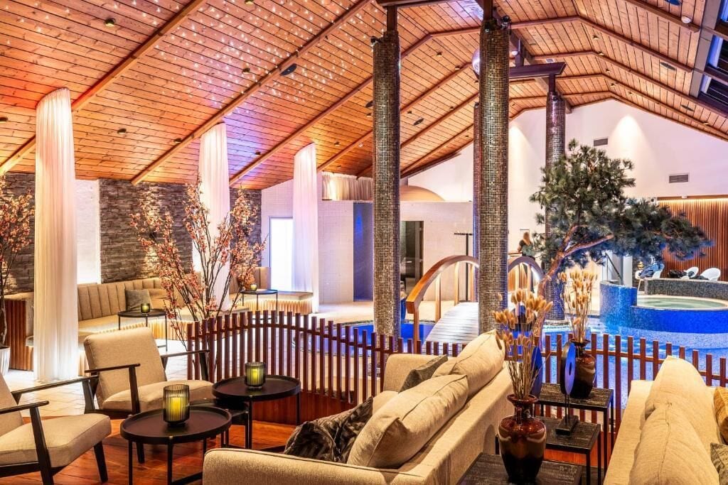 A spacious indoor area with a high ceiling, seating arrangements, and a decorative water feature.