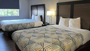 A hotel room with two beds, each with patterned bedding and a wooden headboard. - Motel 6 Tucson, AZ – Airport / Kino Sports Complex (Tucson)