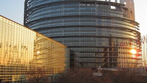 Ein modernes, kreisförmiges Gebäude mit Glasfassade und mehreren Etagen.