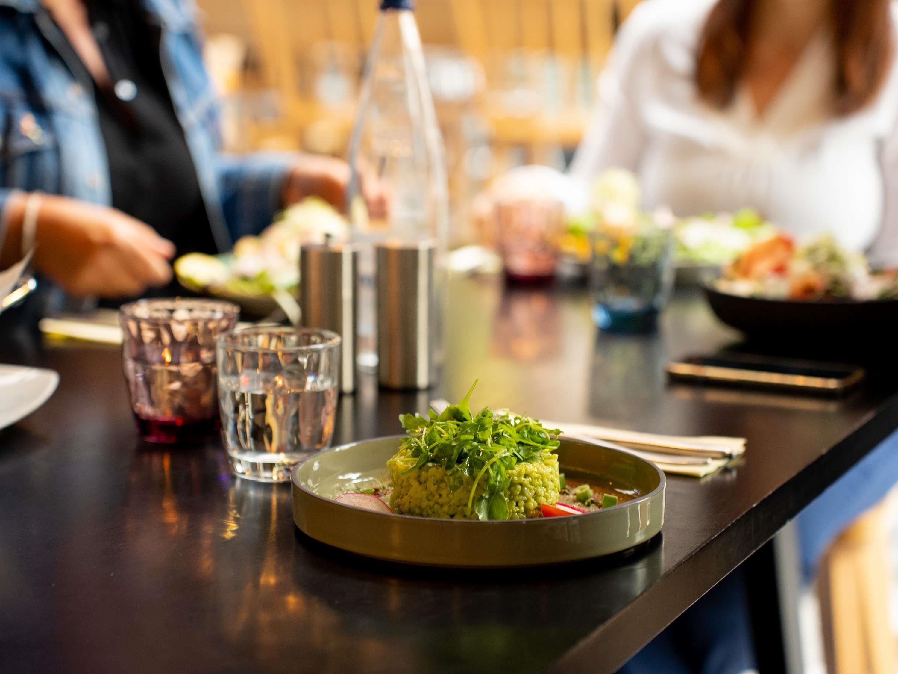 Une table à manger avec une assiette de nourriture, des verres et une bouteille.