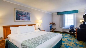 A hotel room with a large bed, a desk with a chair, a window with curtains, and a painting on the wall. - La Quinta Inn by Wyndham Norfolk Virginia Beach (Virginia Beach)