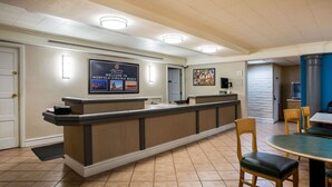 A reception area with a counter, chairs, and a tiled floor. - La Quinta Inn by Wyndham Norfolk Virginia Beach (Virginia Beach)