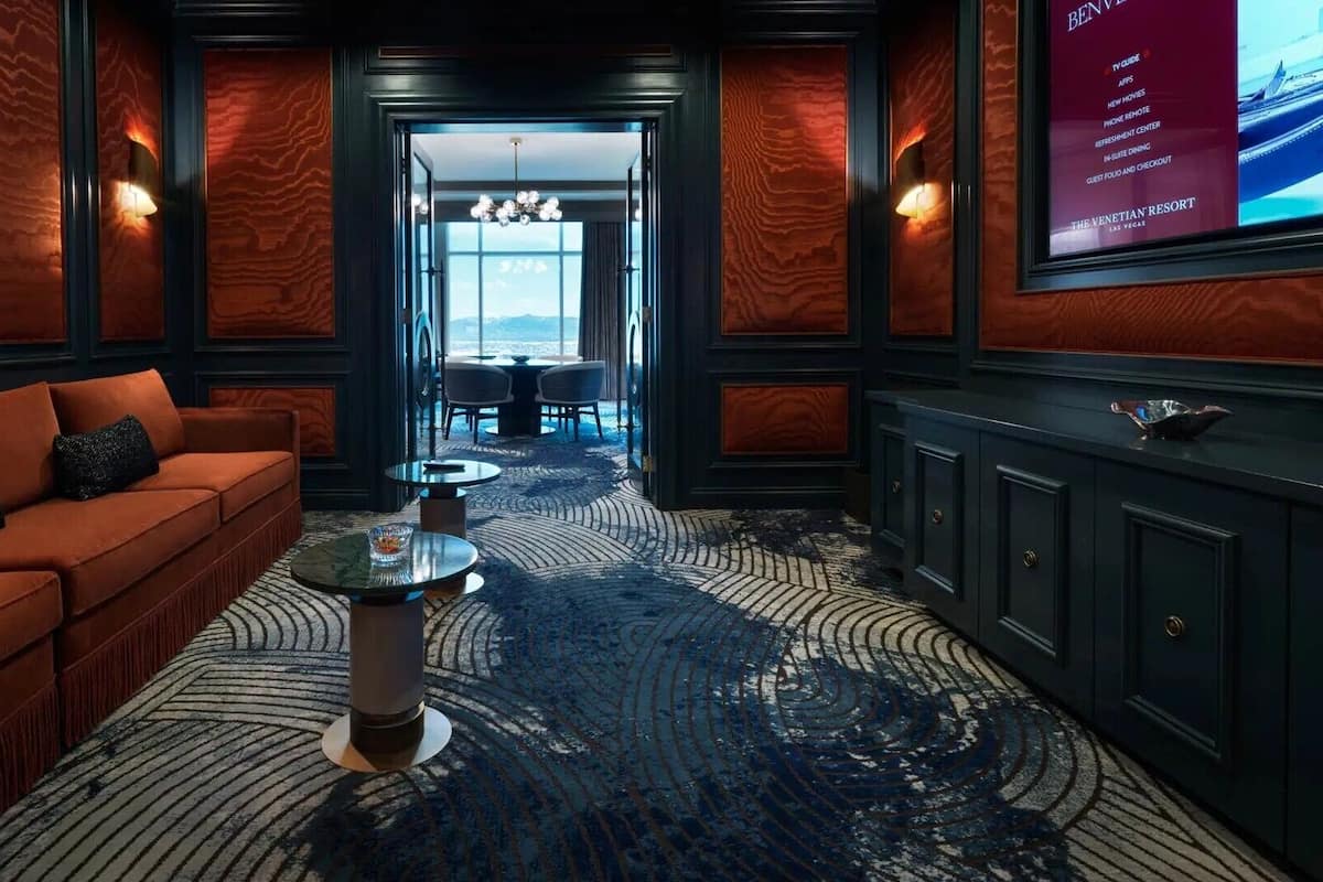 A hotel lobby with a red sofa, a coffee table, and a view of the ocean through a large window.