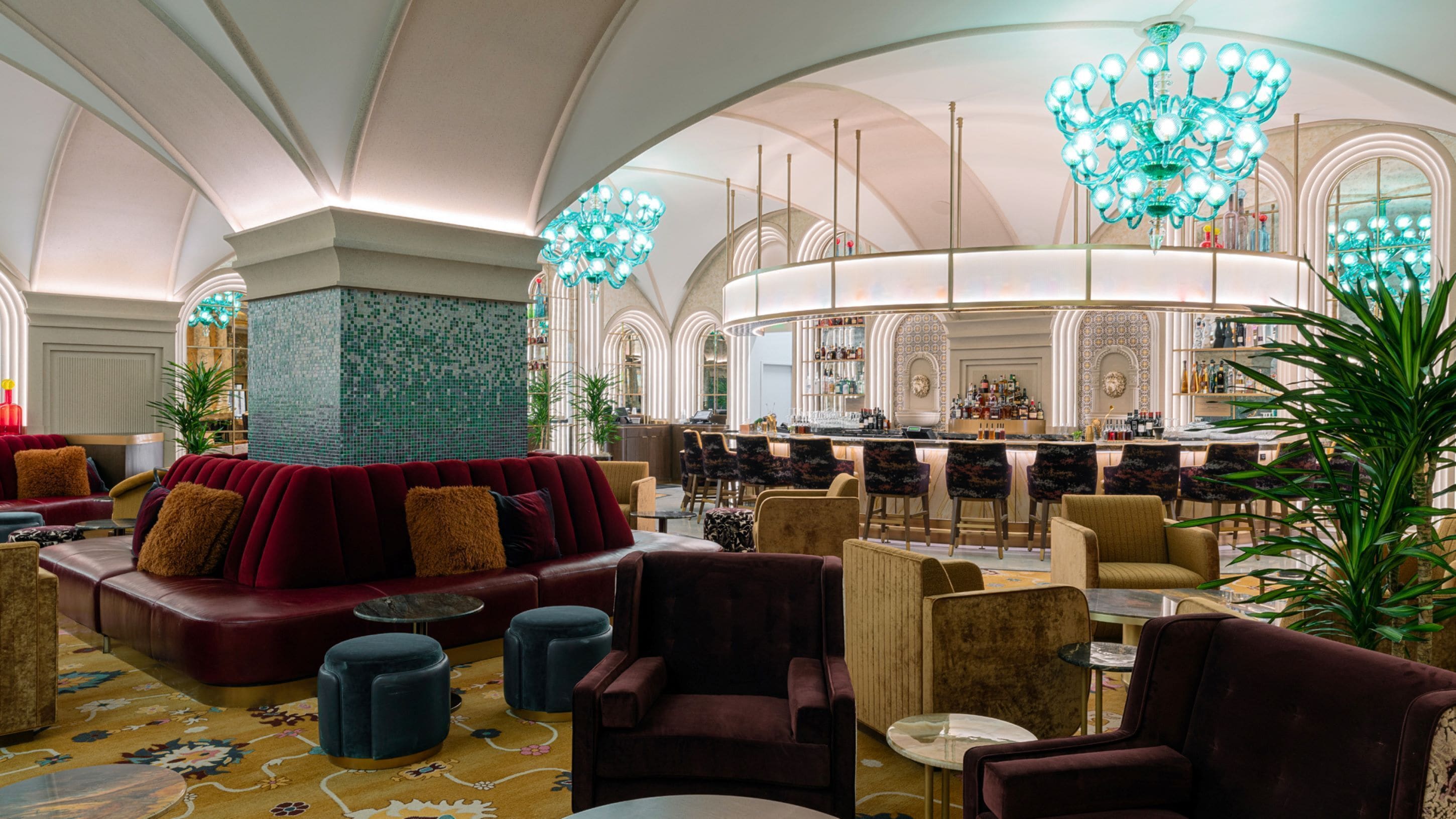 Een ruime lobby met een bar, zitgedeeltes en een sierlijke kroonluchter.