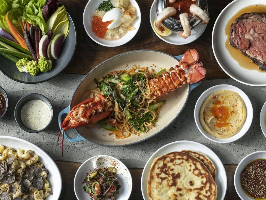 On y propose une variété de plats, notamment du homard, des pâtes et un steak, ce qui laisse supposer un choix de menus très diversifié.
