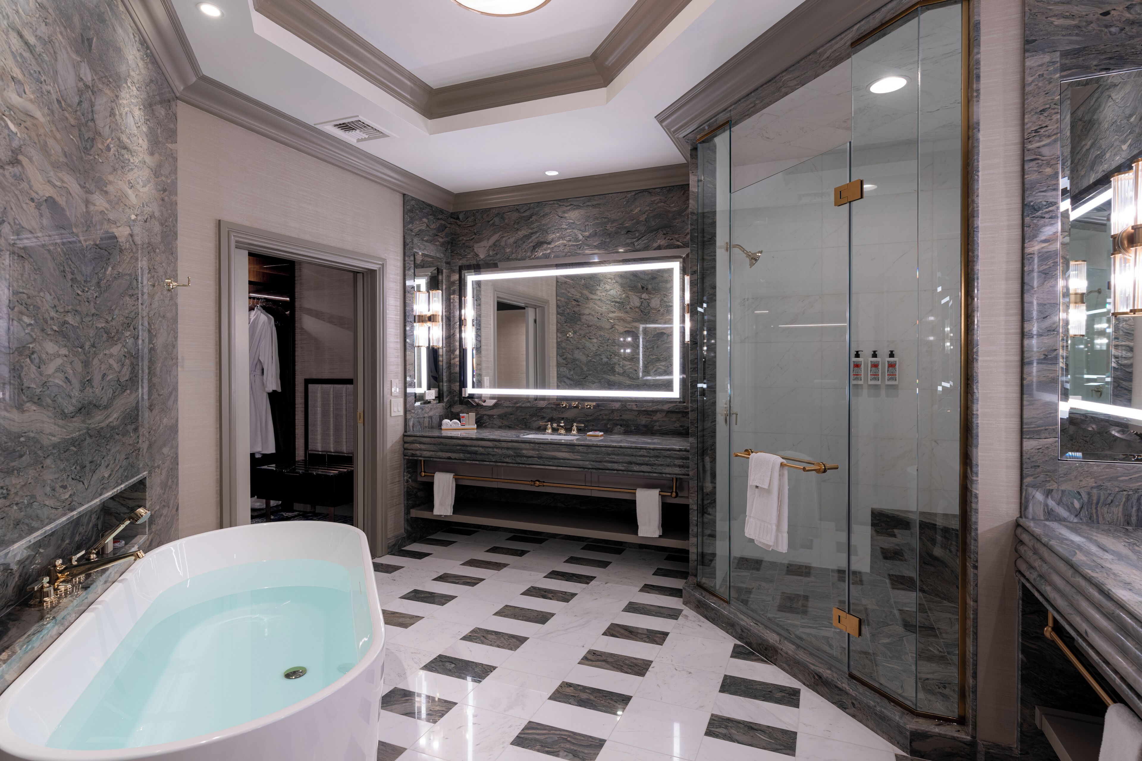 Un bagno moderno con una vasca freestanding, una doccia con pareti in vetro e un grande specchio sopra il lavabo.