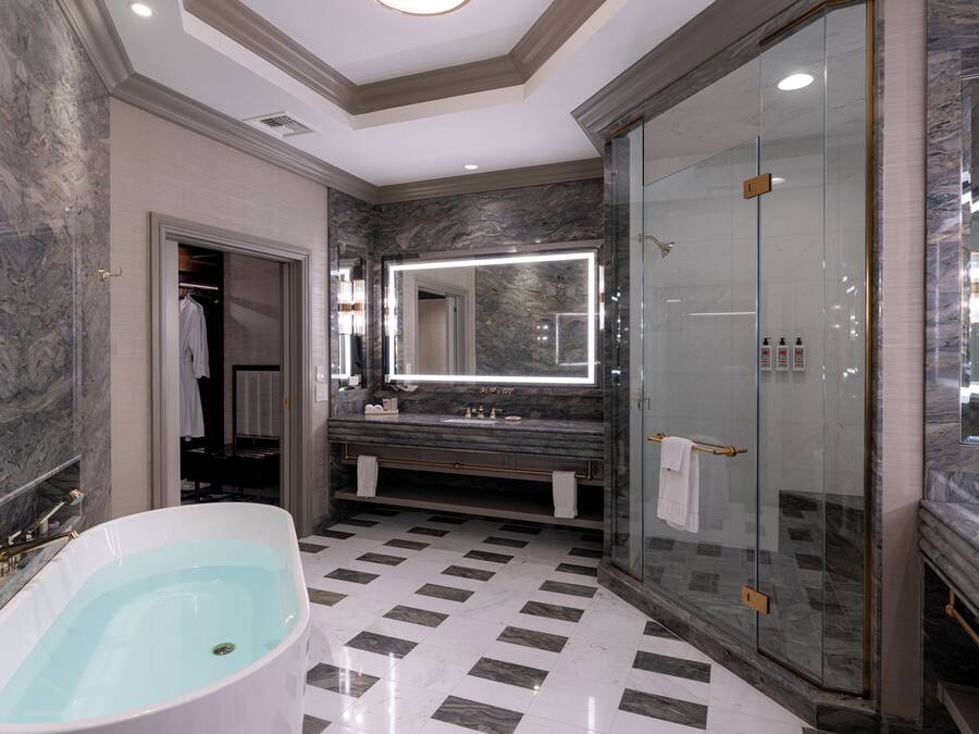 A modern bathroom with a freestanding bathtub, a glass-enclosed shower, and a large mirror above the vanity.