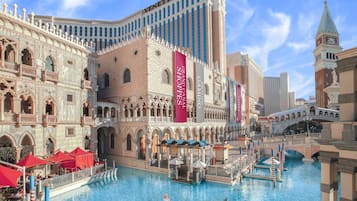 A grand hotel with a large pool, gondolas, and a Venetian-themed facade.