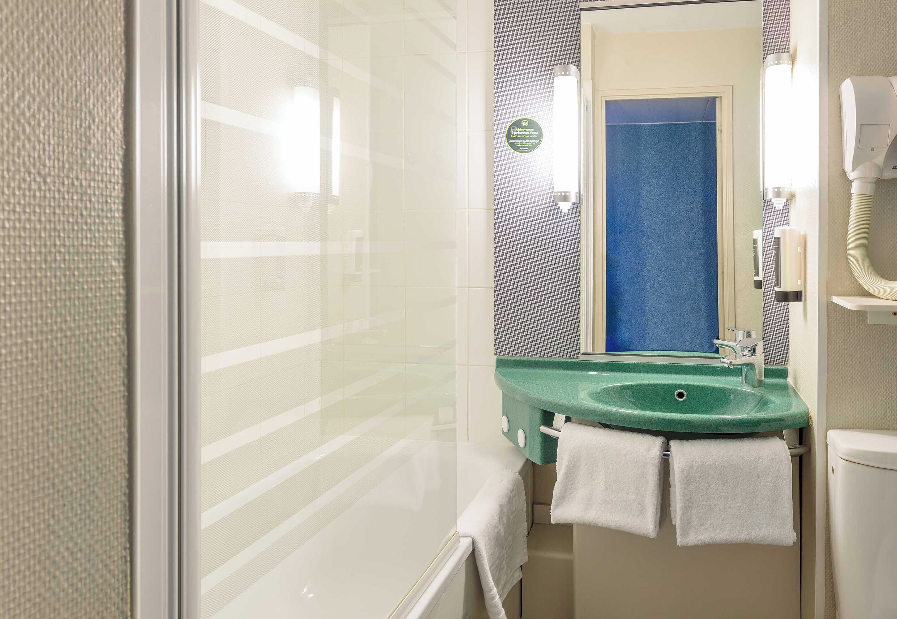 bathtub, eco-friendly toiletries, hair dryer, towels