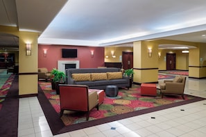 A hotel lobby with a sofa, chairs, a fireplace, and a patterned carpet. - Holiday Inn Norwich by IHG (Norwich)