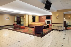 A lobby with a sofa, chairs, a fireplace, and a television. - Holiday Inn Norwich by IHG (Norwich)