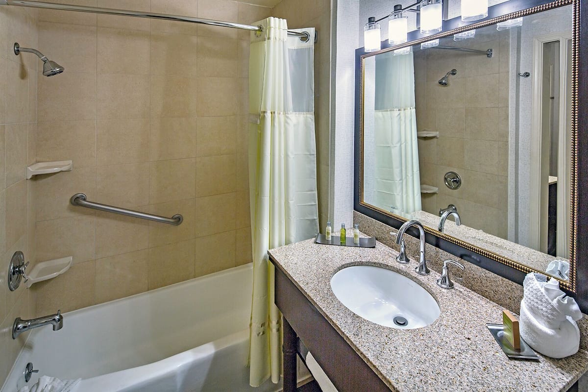 أغطية فراش متميزة وخزنة داخل الغرفة ومكتب وستائر تعتيم