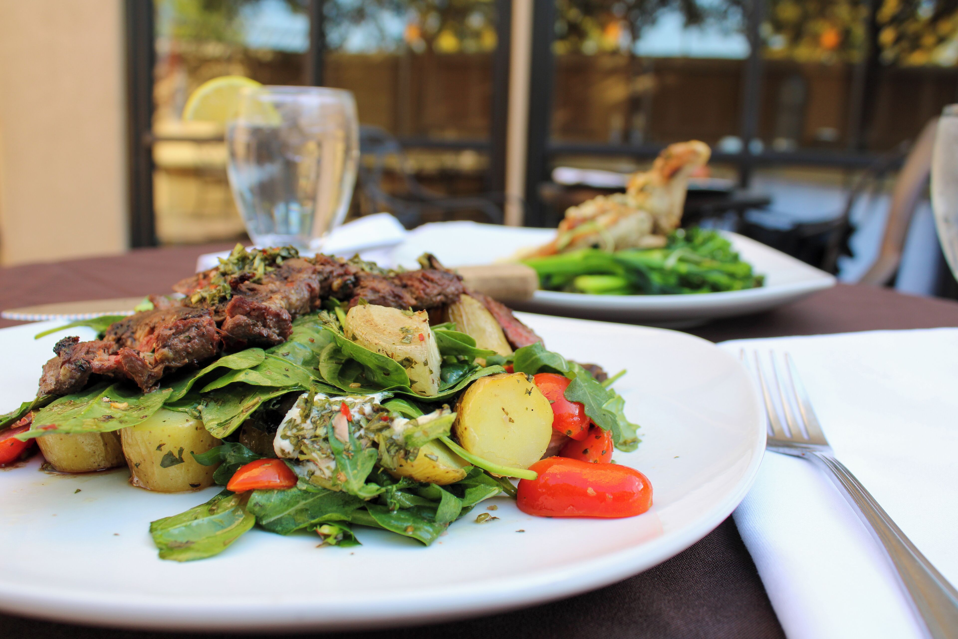 A plate of food with meat, potatoes, and greens.