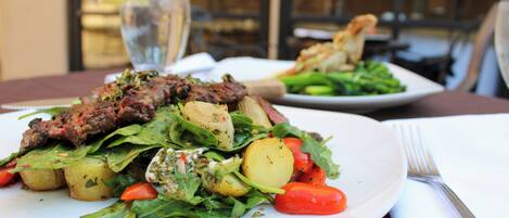 A plate of food with meat, potatoes, and greens.