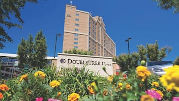 DoubleTree Hotel features a modern exterior with a prominent sign and beautiful gardens.