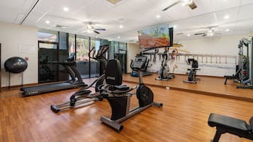 Un gimnasio con cintas de correr, elípticas y pesas sueltas.