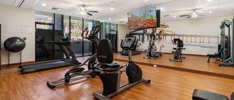 A gym with treadmills, elliptical machines, and free weights.