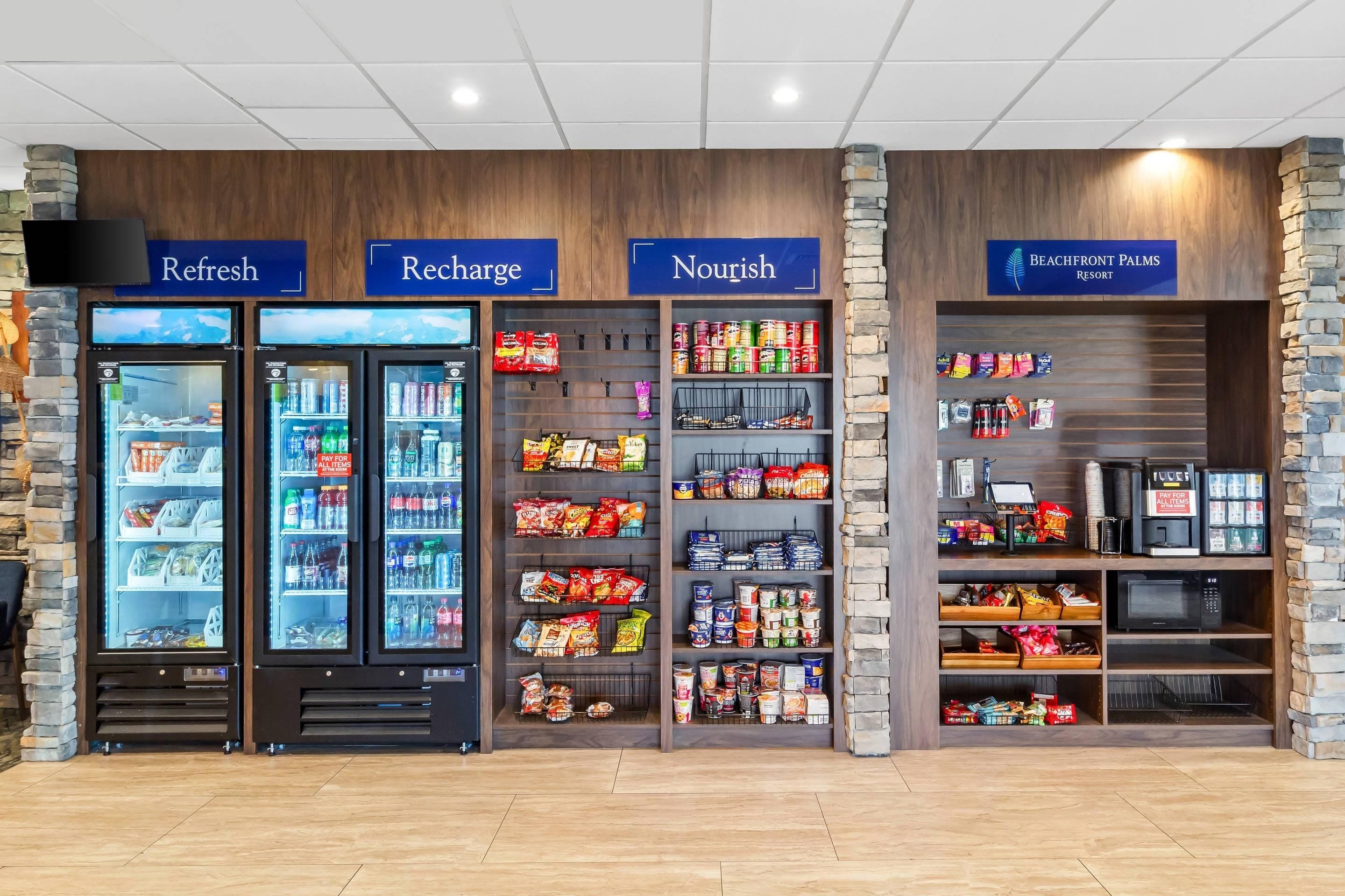 A refreshment kiosk with labeled sections for 'Refresh', 'Recharge', and 'Nourish', stocked with beverages and snacks.