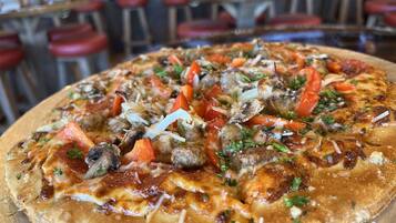 Una pizza con varios ingredientes sobre una tabla de madera.