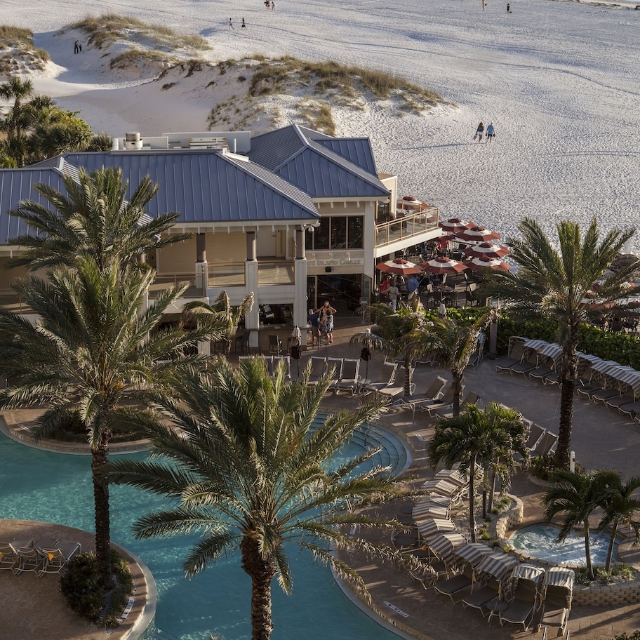 A resort with a pool, beach, and pier.