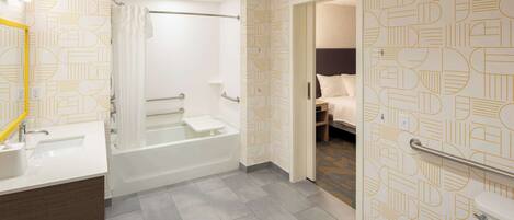 A modern bathroom with a bathtub, shower, and toilet.