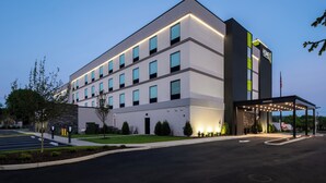 Un hotel moderno con techo plano, múltiples ventanas y una zona de entrada cubierta.
