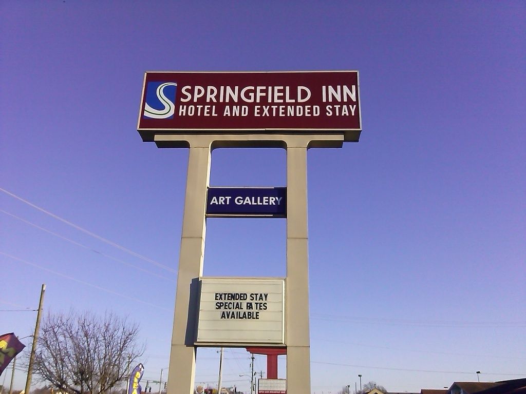 Letrero del Hotel Springfield Inn y Estancia Extendida, con Galería de Arte y tarifas especiales para estancias prolongadas.