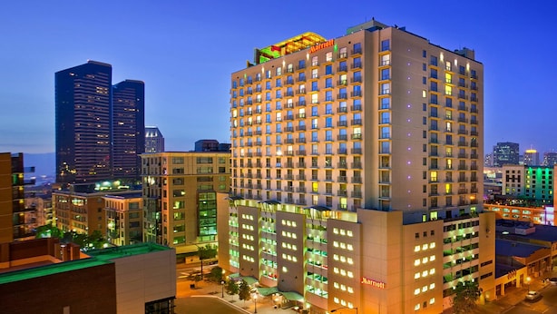 A Marriott hotel with multiple floors, balconies, and a cityscape in the background.