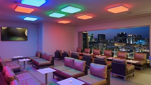 A modern lounge area with multiple seating options, including sofas and chairs, arranged around tables.