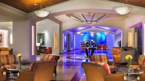 A spacious lobby with a central seating area, a reception desk, and a modern ceiling design.