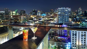 A cocktail on a balcony with a cityscape view.