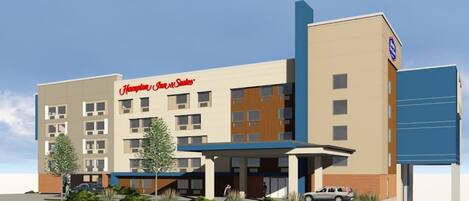 Un hotel Hampton Inn & Suites de diseño moderno, con varios pisos, entrada cubierta y área de estacionamiento.