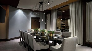 Un comedor moderno con una mesa larga, varias sillas y un candelabro.