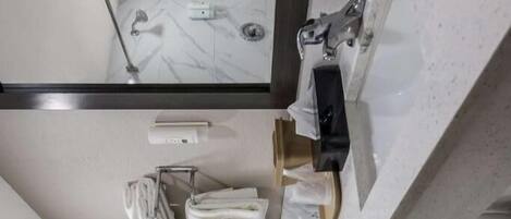 Un baño con piso de mármol, un lavamanos con espejo, toallero, inodoro y un cuadro en la pared.