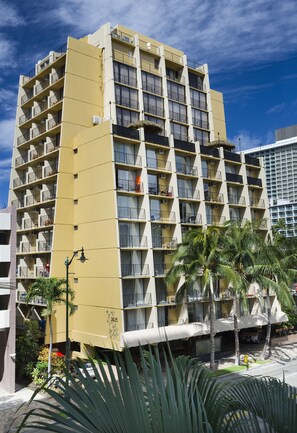 A multi-story hotel with balconies, palm trees, and a clear sky. - Castle Bamboo Waikīkī Hotel (Honolulu)
