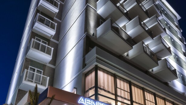 A multi-story hotel with a modern design, featuring a prominent entrance with a red carpet and a sign that reads "ABNER'S".