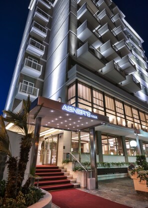 A multi-story hotel with a modern design, featuring a prominent entrance with a red carpet and a sign that reads "ABNER'S". - Hotel Abner's (Riccione)