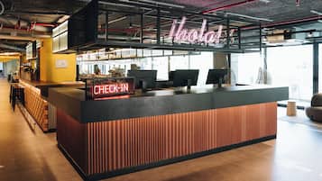 Una moderna reception con un neon, una zona relax e vista sulla città attraverso ampie finestre.