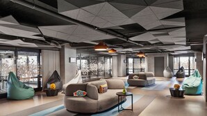 Un área de lounge moderna con un sofá modular, pufs y una pequeña mesa de centro.