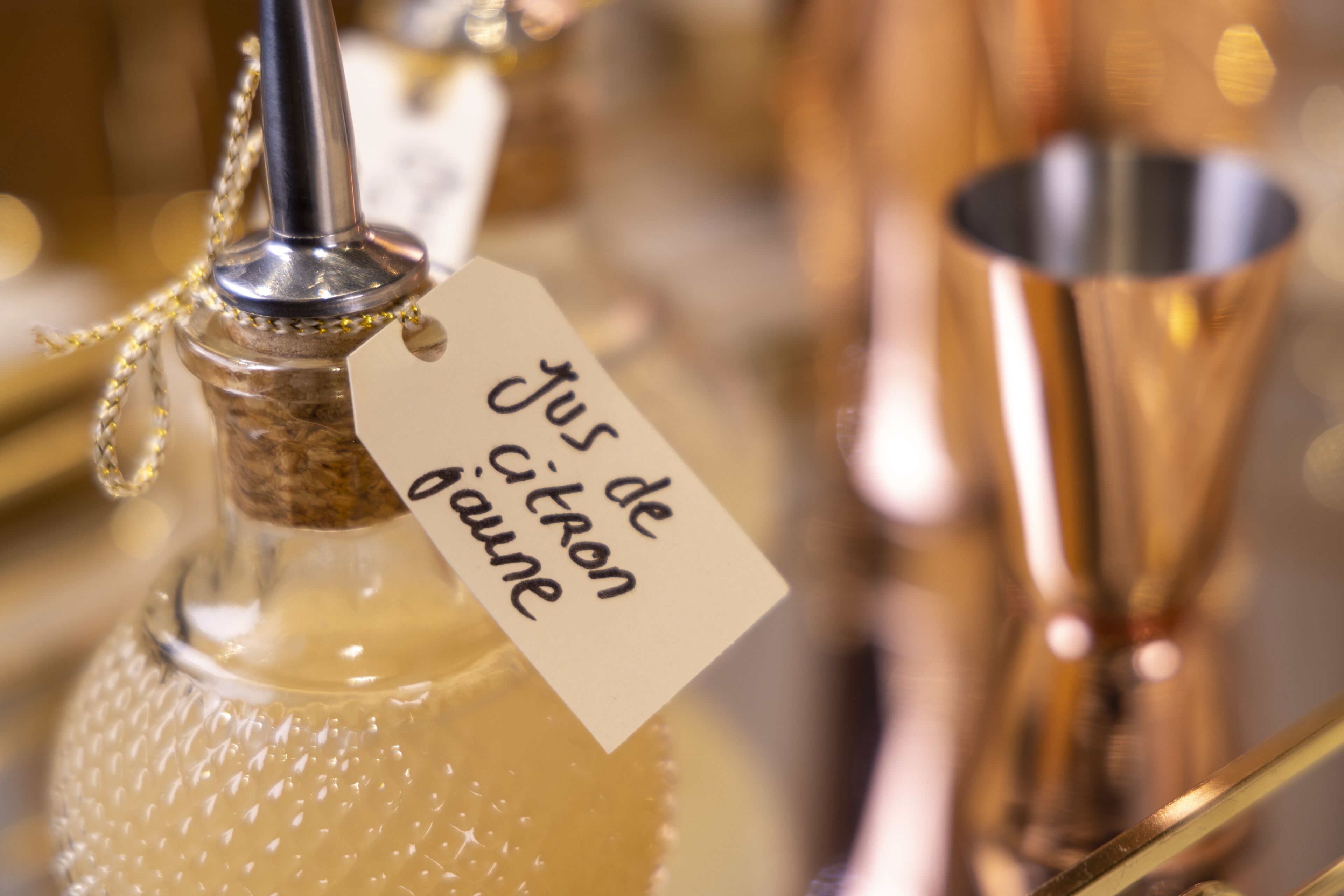 A close-up of a bottle with a tag that reads "jus de citron citron jaune".