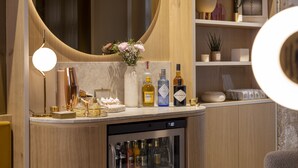 Eine Bar mit einer Marmorplatte, einem Kühlschrank und verschiedenen Flaschen und Gläsern.